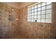 Shower with tile surround and glass block window providing natural light at 21206 Canoe Pass St, Clermont, FL 34715