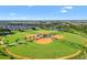 Aerial view of the community baseball field and facilities, showing well-maintained green spaces and a pond at 2321 Demarco Dr, The Villages, FL 32163