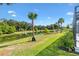 Picturesque backyard with a serene pond view, lush green grass, and mature trees, creating a relaxing outdoor oasis at 2321 Demarco Dr, The Villages, FL 32163