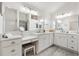 Bright bathroom showcasing dual vanities, a makeup table, and a decorative stool at 2321 Demarco Dr, The Villages, FL 32163