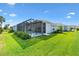 A lovely home features a large, screened lanai overlooking the sprawling green lawn at 2321 Demarco Dr, The Villages, FL 32163