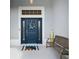 Inviting front entryway with a blue door, covered entry, bench, and decorative wreath at 2321 Demarco Dr, The Villages, FL 32163