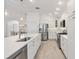 Contemporary kitchen with stainless steel appliances, white cabinets, and an island with barstool seating at 2321 Demarco Dr, The Villages, FL 32163