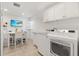 Well-lit laundry room featuring a modern washer/dryer, TV and workspace at 2321 Demarco Dr, The Villages, FL 32163
