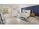 Spacious main bedroom with abundant natural light, a blue accent wall, and stylish decor at 2321 Demarco Dr, The Villages, FL 32163
