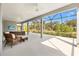 A beautiful covered patio with ceiling fans and wicker furniture overlooks a manicured lawn and pond at 2321 Demarco Dr, The Villages, FL 32163