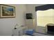 Relaxing bedroom features a striped bed, artwork, and desk area bathed in natural light from the window at 2388 Branchville Ter, The Villages, FL 32162