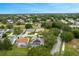Aerial view of home with solar panels, screened-in pool, lush landscaping, and close proximity to a golf course at 25236 Waterbridge Ct, Leesburg, FL 34748
