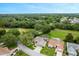 Stunning aerial view of home featuring solar panels, a screened in pool, beautiful landscaping and golf course views at 25236 Waterbridge Ct, Leesburg, FL 34748