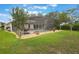 Manicured backyard with screened-in pool area, stone accents and lush lawn at 25236 Waterbridge Ct, Leesburg, FL 34748