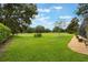 Expansive lawn extends from the property, bordered by mature trees offering a tranquil setting at 25236 Waterbridge Ct, Leesburg, FL 34748