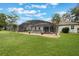 Relaxing backyard oasis featuring a screened pool and lush green lawn, perfect for outdoor enjoyment at 25236 Waterbridge Ct, Leesburg, FL 34748