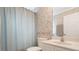 Powder room with floral wallpaper, blue shower curtain, and white fixtures at 25236 Waterbridge Ct, Leesburg, FL 34748