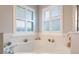 Bright bathroom features soaking tub with shuttered windows at 25236 Waterbridge Ct, Leesburg, FL 34748