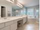 Bright bathroom boasts double sinks, a soaking tub, and glass shower with tile floors at 25236 Waterbridge Ct, Leesburg, FL 34748