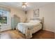 Bedroom with wood floors, a ceiling fan, and a window overlooking a private lanai at 25236 Waterbridge Ct, Leesburg, FL 34748