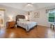 Comfortable bedroom with hardwood floors, side tables, and a window offering natural light at 25236 Waterbridge Ct, Leesburg, FL 34748