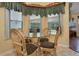 Cozy breakfast nook with a glass table and wicker chairs, overlooking the lanai at 25236 Waterbridge Ct, Leesburg, FL 34748