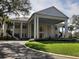 Elegant community clubhouse featuring a grand entrance, classic architectural details, and lush landscaping at 25236 Waterbridge Ct, Leesburg, FL 34748
