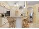 Eat-in kitchen featuring granite countertops, arched doorways, white cabinets, and counter seating at 25236 Waterbridge Ct, Leesburg, FL 34748