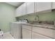 Practical laundry room features granite counters, upper cabinets, and modern washer/dryer at 25236 Waterbridge Ct, Leesburg, FL 34748