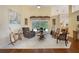 Open-concept living room with neutral carpet, vaulted ceiling, and sliding glass doors to the lanai at 25236 Waterbridge Ct, Leesburg, FL 34748
