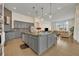 Modern kitchen featuring gray cabinetry, granite countertops, stainless steel appliances, and tile floors at 2666 Meadowedge Loop, St Cloud, FL 34772