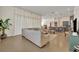Spacious living room featuring a large sofa, neutral tones, tile floors, and flowing white curtains at 2666 Meadowedge Loop, St Cloud, FL 34772