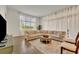 Comfortable living room with a sectional sofa, natural light, tile flooring, and sheer window coverings at 2666 Meadowedge Loop, St Cloud, FL 34772