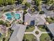 Aerial view of clubhouse area featuring pool, putting green, gathering area, and lush landscaping at 27018 Nature View St, Leesburg, FL 34748