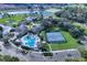 Aerial view of a community featuring mature trees, tennis courts, multiple pools, a clubhouse, and ponds at 27018 Nature View St, Leesburg, FL 34748