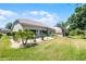 The backyard features a well-manicured lawn, a cozy patio area, and lush tropical landscaping for privacy at 27018 Nature View St, Leesburg, FL 34748