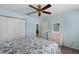 This bedroom has light blue walls, a ceiling fan, carpeted flooring, and a closet with white doors at 27018 Nature View St, Leesburg, FL 34748