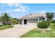 Charming home featuring a well-manicured lawn, lovely landscaping, and an attached two-car garage at 27018 Nature View St, Leesburg, FL 34748