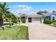Charming home featuring a well-manicured lawn, lovely landscaping, and an attached two-car garage at 27018 Nature View St, Leesburg, FL 34748