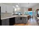 Spacious kitchen with gray cabinets, granite counters, and eat-in nook under vaulted ceilings at 27018 Nature View St, Leesburg, FL 34748