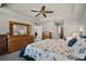 The main bedroom features wood furniture, a seashell patterned bedspread, and an ensuite bathroom and closet at 27018 Nature View St, Leesburg, FL 34748