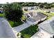 Aerial view showing a well-maintained home, lush lawn, landscaping, and driveway in a quiet neighborhood at 27146 Greenfly Orchid Ln, Leesburg, FL 34748