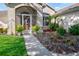 Close up of the front entrance featuring a charming screen door and fresh landscaping at 27146 Greenfly Orchid Ln, Leesburg, FL 34748