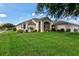 Well-maintained home featuring a manicured lawn and decorative landscaping at 27146 Greenfly Orchid Ln, Leesburg, FL 34748
