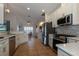 Bright kitchen features stainless steel appliances, light countertops, and white cabinetry at 27146 Greenfly Orchid Ln, Leesburg, FL 34748