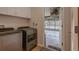 Bright laundry room adjacent to the garage features modern washer and dryer and convenient access at 27146 Greenfly Orchid Ln, Leesburg, FL 34748