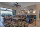 Cozy living room featuring comfortable sofas, ceiling fan, and seamless access to the lanai at 27146 Greenfly Orchid Ln, Leesburg, FL 34748