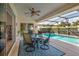 Outdoor patio with ceiling fan, table and chairs, and view of the sparkling pool at 27146 Greenfly Orchid Ln, Leesburg, FL 34748