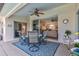 Inviting covered patio featuring a ceiling fan, dining set, and seamless access to the interior living space at 27146 Greenfly Orchid Ln, Leesburg, FL 34748