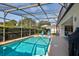 Refreshing screened-in pool area with sun loungers, providing a relaxing outdoor oasis for enjoyment at 27146 Greenfly Orchid Ln, Leesburg, FL 34748
