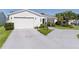 Charming single-story home with lush landscaping, concrete driveway, and a two car garage at 2785 Privada Dr, The Villages, FL 32162