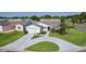 Charming single-story home with a well-manicured lawn and a circular driveway leading to the attached garage at 2785 Privada Dr, The Villages, FL 32162