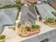 Aerial view of a well-maintained home featuring a manicured front yard with decorative landscaping and a neutral color scheme at 3074 Eastwood Ter, The Villages, FL 32163