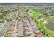 An aerial view of a residential area with a golf course and lake, showcasing community amenities and serene surroundings at 3074 Eastwood Ter, The Villages, FL 32163
